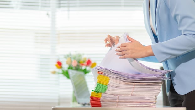 A woman in a suit holding a stack of papers photo