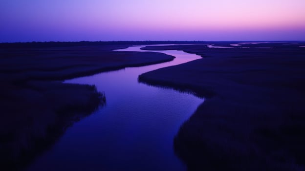A river runs through a marsh at sunset photo