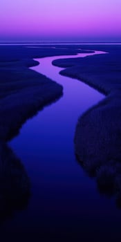 A river flows through a marsh at dusk photo