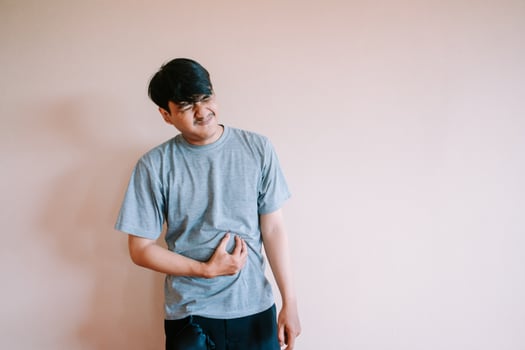 Man Experiencing Abdominal Pain and Discomfort Holding Stomach In Agony photo
