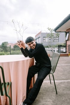 Smiling young man seated at outdoor cafe enjoying leisure moment photo