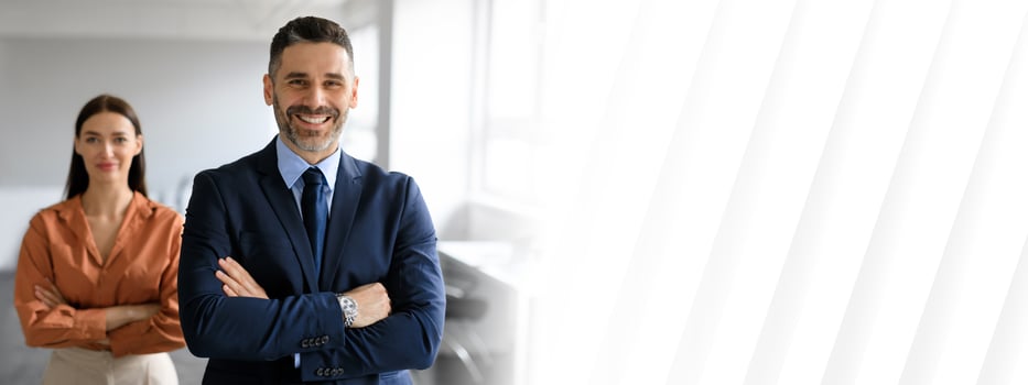 A businessman and businesswoman stand confidently in a well-lit office, symbolizing teamwork and success. Their professional attire reflects a dynamic corporate environment conducive to cooperation. photo