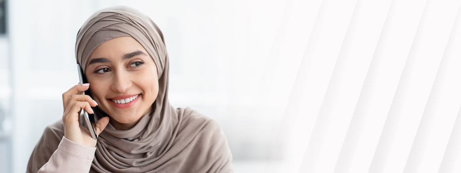 Phone Call. Smiling Muslim Woman In Hijab Talking On Cellphone And Looking Away, Closeup, Copy Space photo