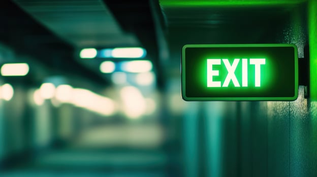 A glowing green exit sign illuminating a dim hallway. photo