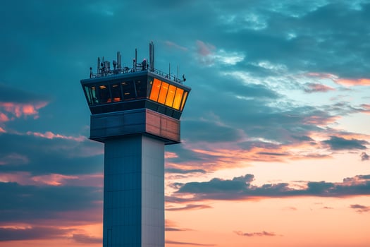 Airport control tower standing tall against a colorful sunset sky photo