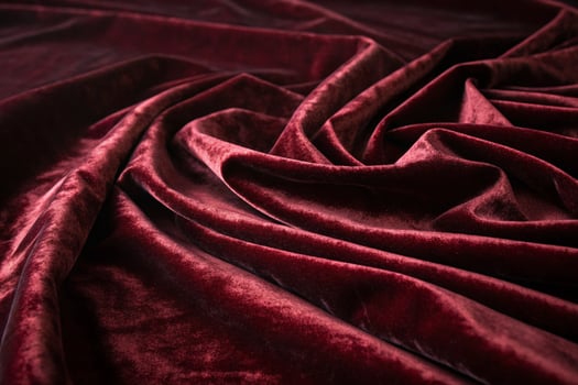flowing velvet fabric in rich red hues, captured in intricate folds, offering a plush background for high end designs photo
