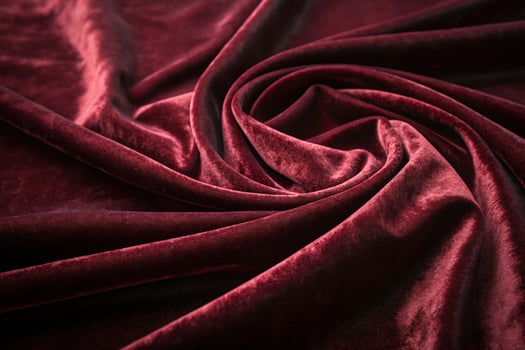 crimson velvet fabric showcasing rich texture and graceful folds, ideal for a sophisticated background photo