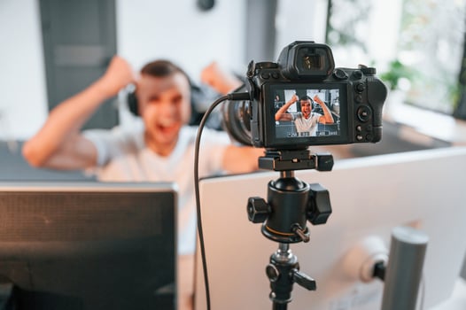Process of recording. Young man playing and streaming the first person shooter game photo