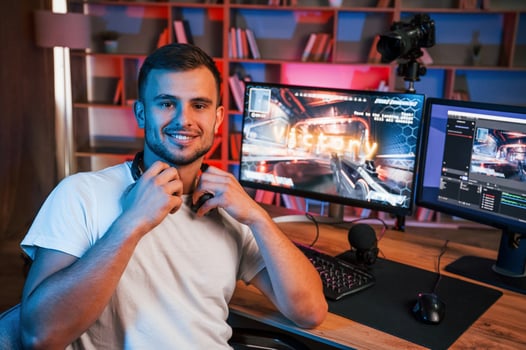Male game streamer in casual ,clothes is indoors, with pc photo