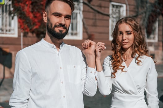 Showing the hands. Beautiful young ,couple is together on the street against old building photo