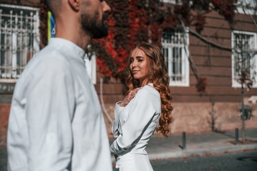 Beautiful young couple is together on the street against old building photo