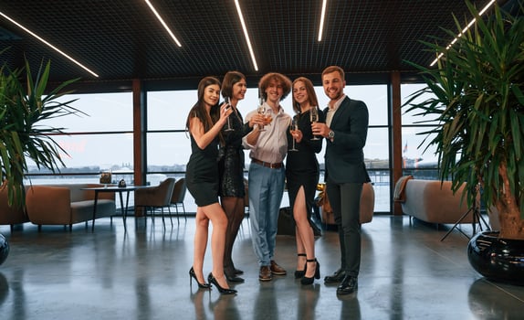 Smiling, for the camera. Group of people in beautiful elegant clothes are celebrating New Year indoors together photo