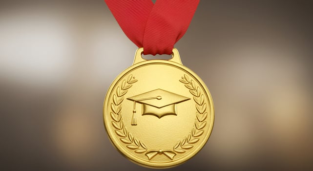 Shiny gold graduation medal with red ribbon photo