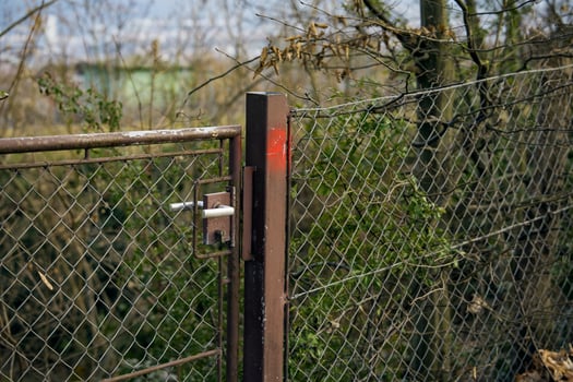 An aged metal fence. The photo shows an old gate made of metal, with rusty elements.