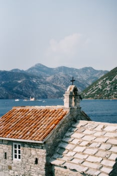 Church of Our Lady of Angels on the shore of the Bay of Kotor with the mountains in the background. Montenegro photo