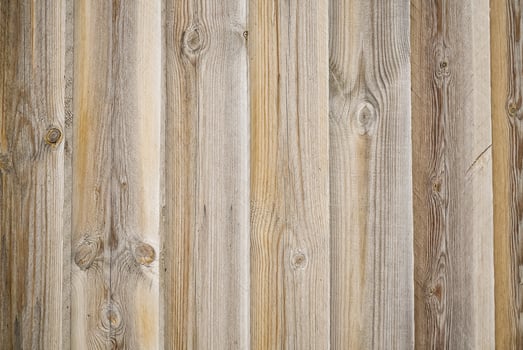 Old weathered wooden fence planks with knots and nail holes. Vertical orientation with a natural wood grain texture. Great background for a rustic or country theme. photo