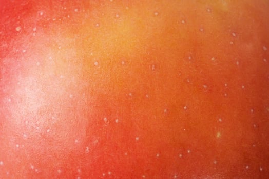 Red apple with yellow color macro photo as background.