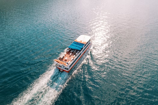 Double-decker excursion ship sails on the blue sea. Top view photo