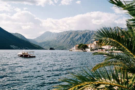 Excursion boat rocks on the waves off the shore of an ancient resort town. Perast, Montenegro photo