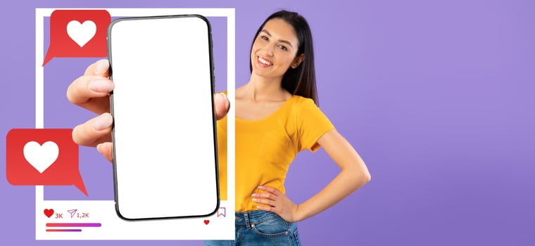 An influencer stands against a solid purple background, holding a smartphone with a blank screen. Chat bubbles and love icons indicate social media interaction and online messaging. photo