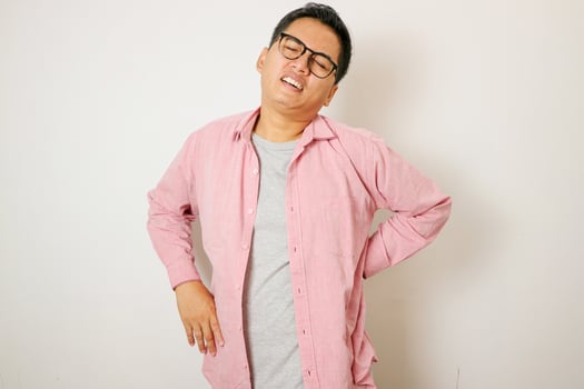 Young Asian man has problem with structural posture He had neck and shoulder pain. Massaged his neck and shoulders for relief. reduce muscle tension. Standing on isolated white background photo