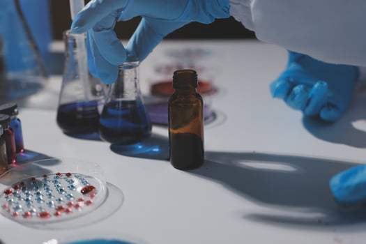 A person in a lab coat is holding a bottle photo
