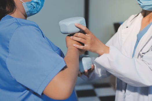 A doctor is holding a dumbbell to a patient photo