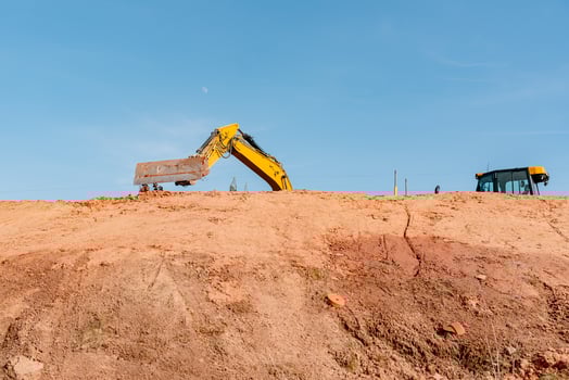 ellow Excavator Digging Earth on Construction Site photo