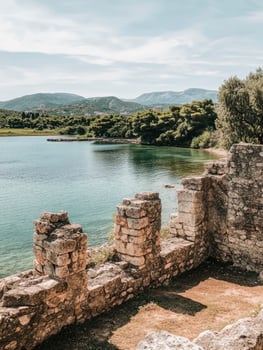 Exploring Ancient Stone Ruins Overlooking Calm Lake and Distant Mountain View photo
