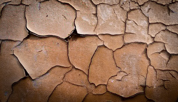 Cracked Texture of Aged Brown Wall Showing Layers of Peeling Paint and Weathered Surfaces in Natural Light photo