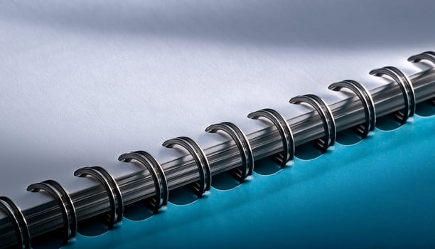 Spiral Notebook Showcasing Metallic Rings and Clean Pages With Soft Shadows and Vibrant Blue Background photo