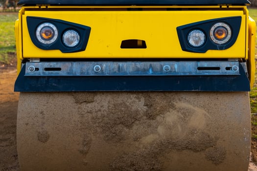 Heavy machinery compactor working on a construction site during daylight photo