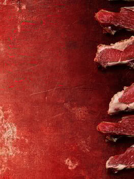 Preparing Fresh Raw Beef Ribeye Steak on Rustic Red Counter photo