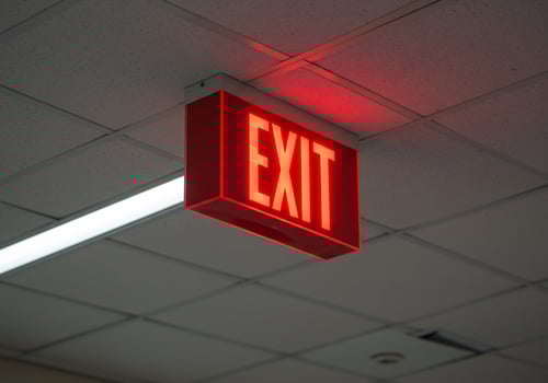 Red Exit Sign Glows Brightly Overhead photo