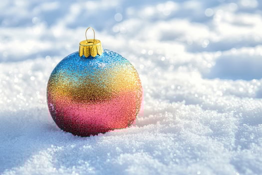 Colorful Christmas Ornament Resting on Fresh Winter Snow in Sunlight photo