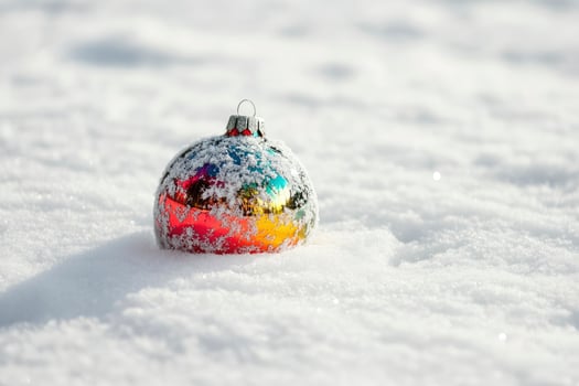 Christmas Ornament Resting in Fresh Snow Colorful Reflections Winter Scene photo