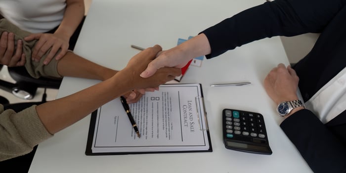 Agreement and Collaboration. A couple shakes hands with their real estate agent to finalize a sale. photo