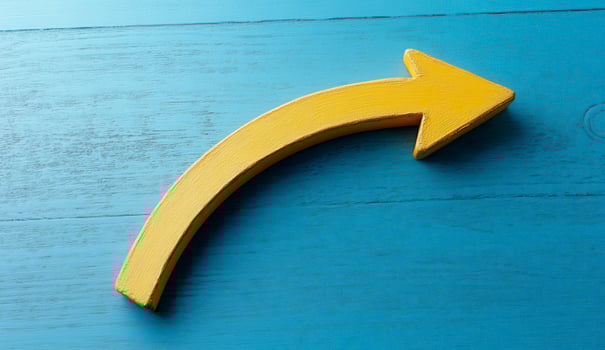 Curved Yellow Arrow on Blue Wood Background photo
