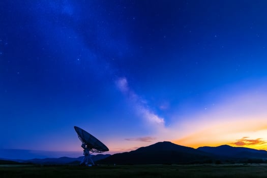 Vast satellite dish reaches for the stars under a shimmering night sky filled with celestial wonders and tranquil mountains photo