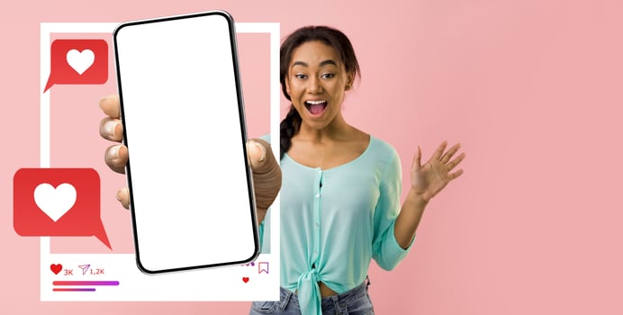 An energetic influencer is holding a smartphone, displaying a blank screen for a new app. She expresses excitement, showcasing the interaction with online messaging and social media. photo