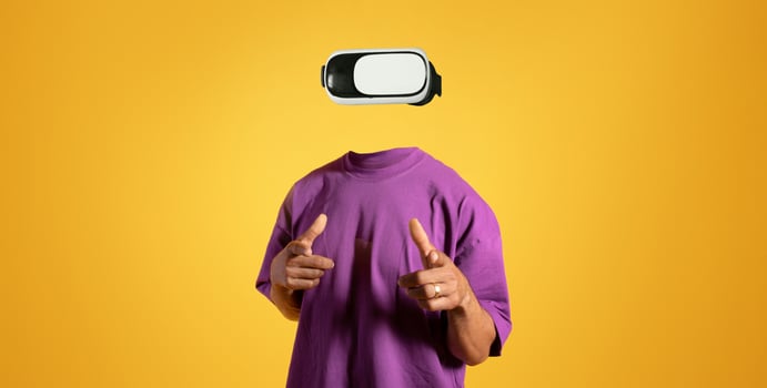 A person wearing virtual reality goggles engages in an immersive experience, showcasing the technology's impact. The bright yellow background enhances the focus on modern gadgets. photo