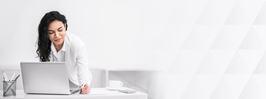 Business People Concept. Beautiful mexican freelancer lady writing notes using laptop computer working online, copy space photo