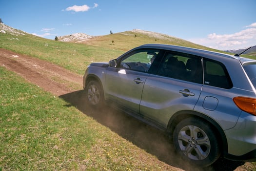 Montenegro, Zabljak - May 09, 2024. SUV is driving along a country road up a green slope. Side view photo