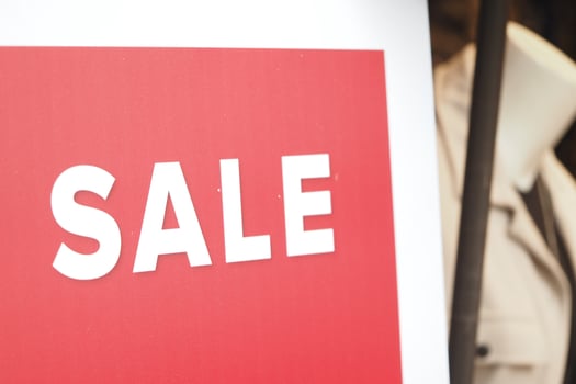 Big sale sign displayed in clothing store window during daytime photo