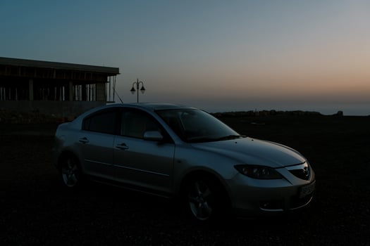 Montenegro, Budva - March 04, 2022. Car stands on the seashore near the building at dusk photo