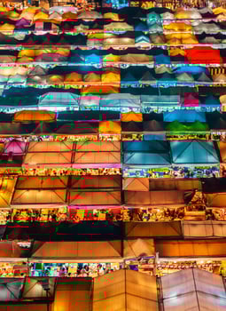 A large crowd of people at a market at night photo