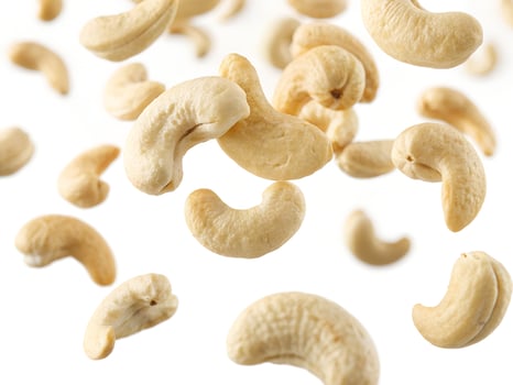 Cashew nuts falling in the air isolated on white photo