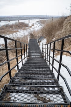 A robust and sturdy set of metal stairs gracefully ascends a snowy hill, offering a clear and safe pathway throughout the winter season, ensuring full accessibility for all individuals photo