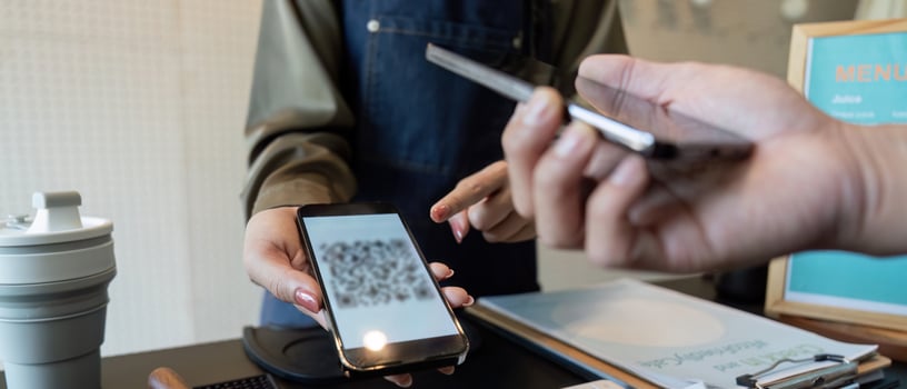Digital Payments and Sustainable Choices in Action. A smartphone payment being facilitated at a coffee shop. photo