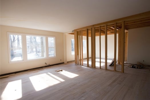 Renovation project showcasing wooden framing in a bright, spacious living room with large windows on a winter day photo